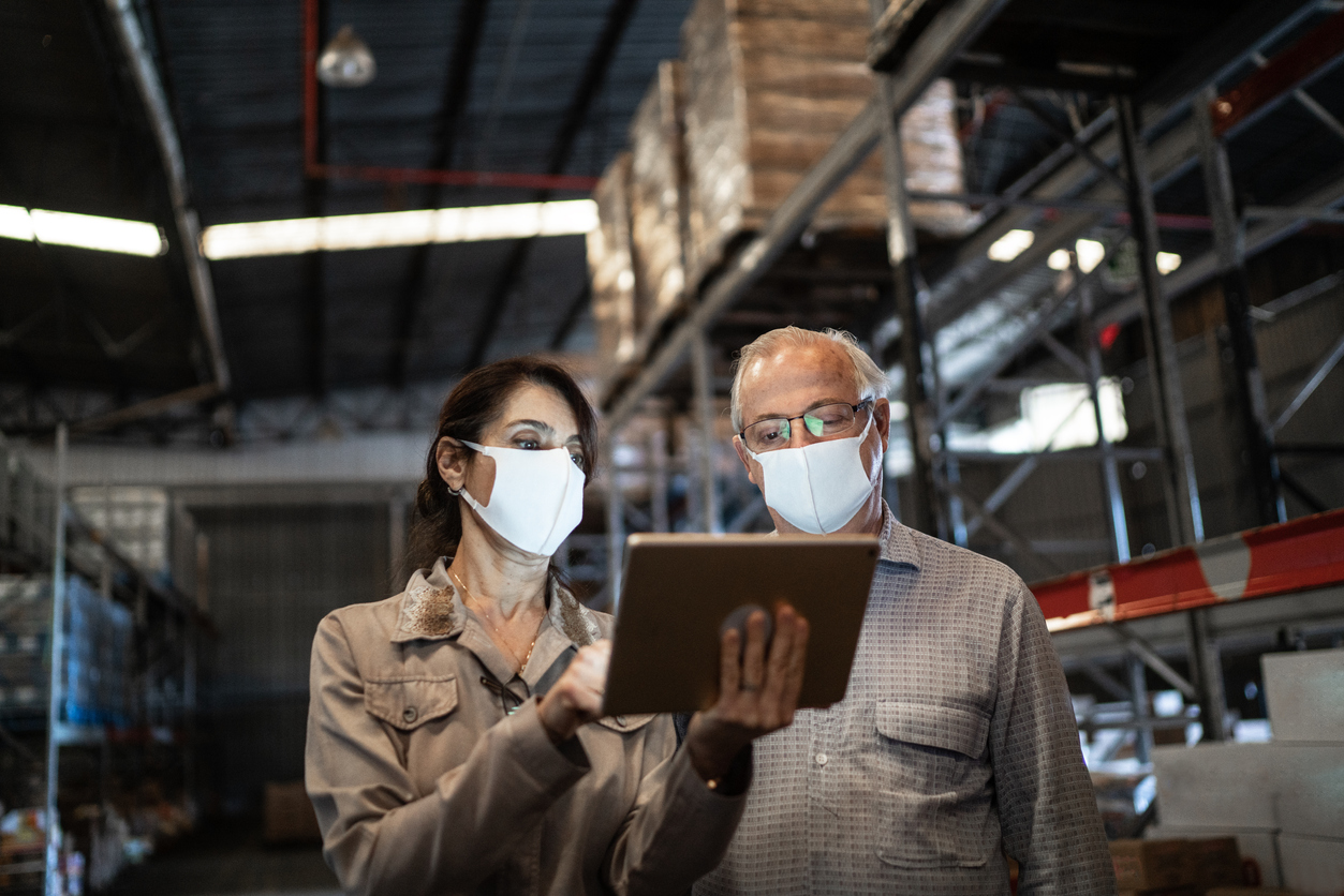 : Mulher e homem utilizam tablet no depósito de produtos de uma loja de materiais de construção.