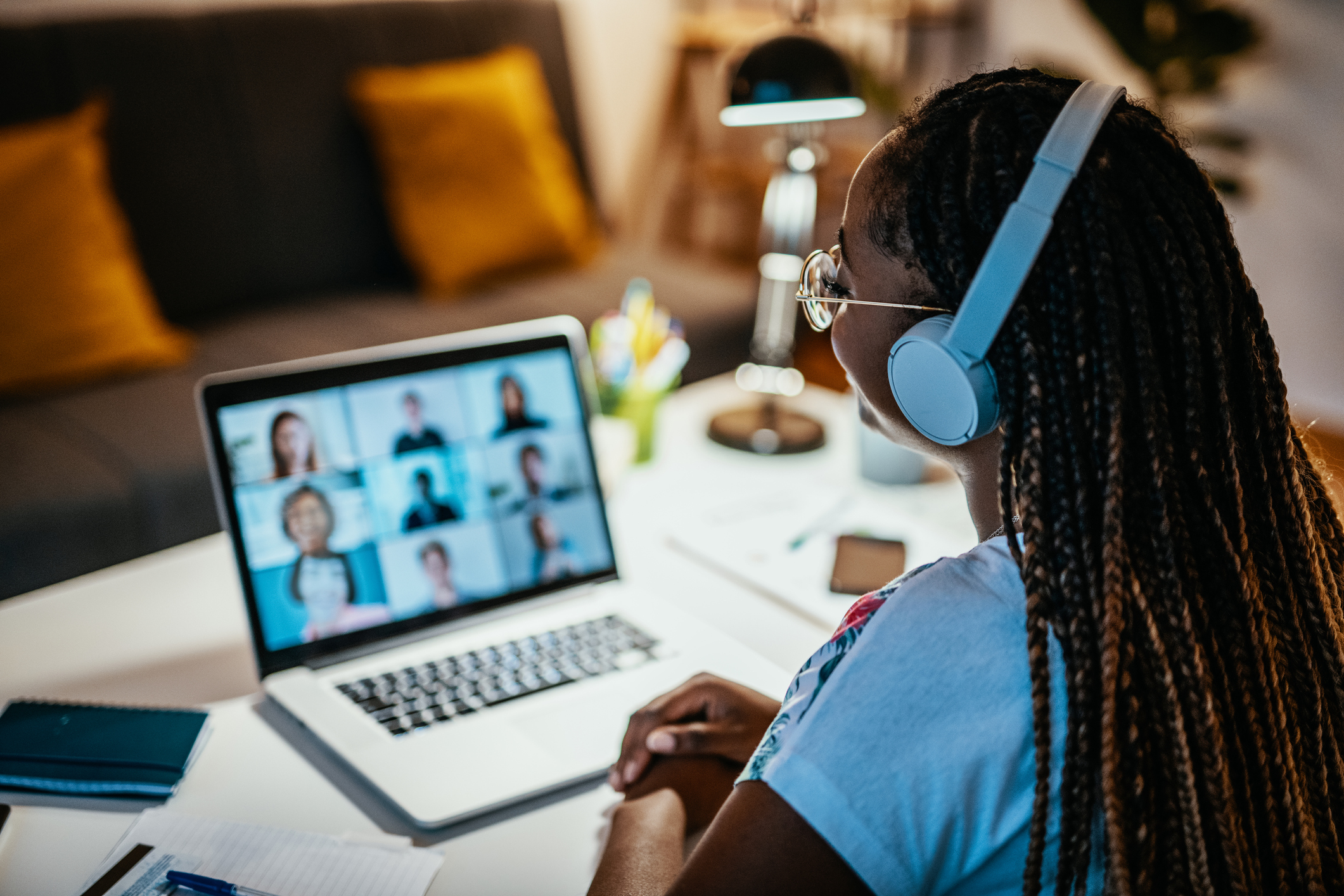 Uma mulher, profissional de tecnologia, faz uma reunião online enquanto trabalha de casa.