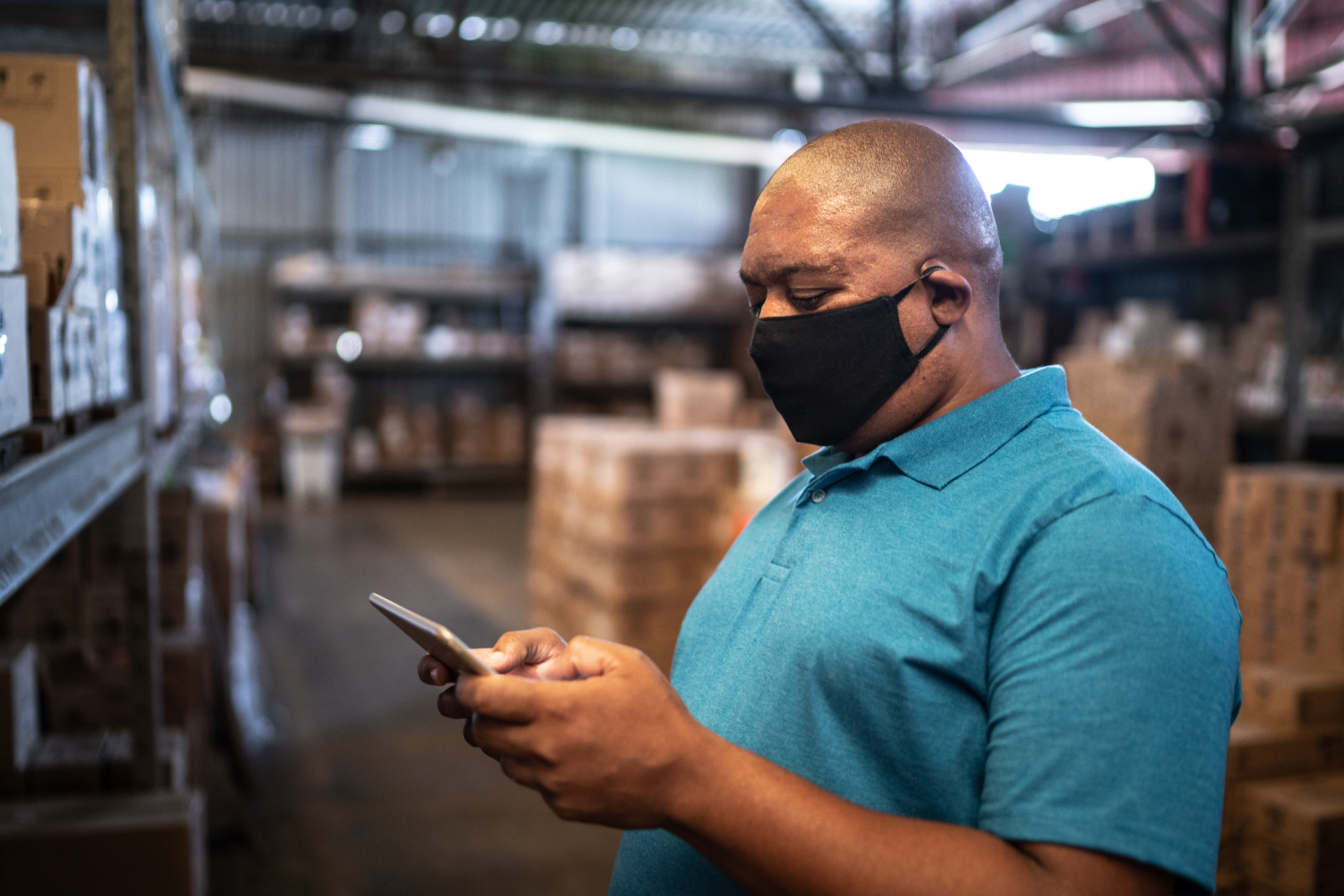 Homem mexe no celular, enquanto consulta produtos de materiais de construção num e-commerce no celular.