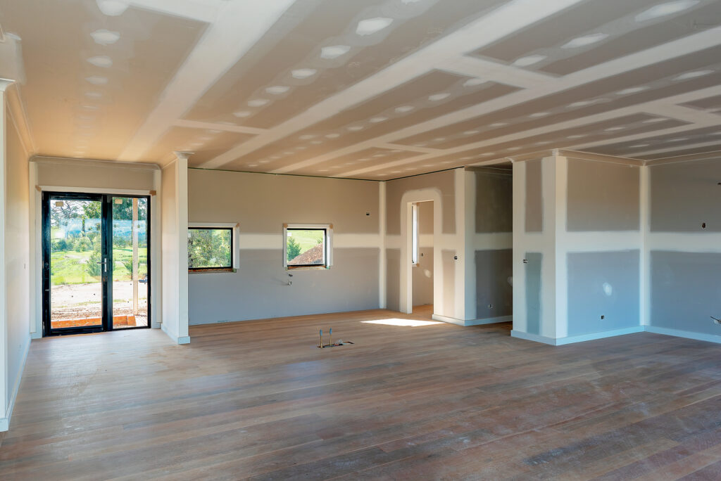 Imagem que mostra uma sala com paredes de drywall, ilustrando a versatilidade desse sistema construtivo.