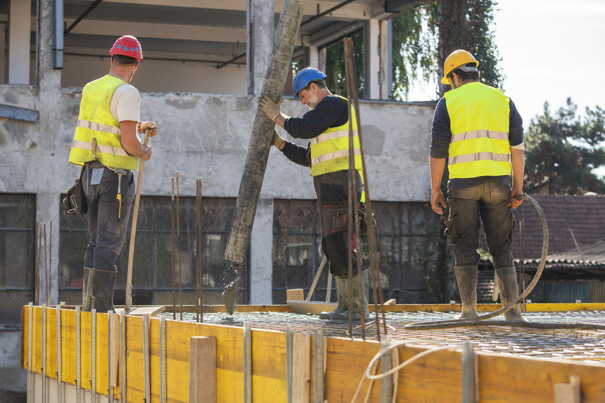 Profissionais de obra colocam um tipo de concreto durante a construção de uma laje