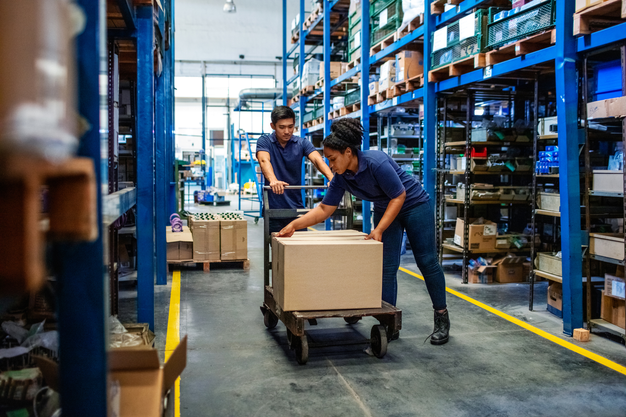 Trabalhadores da loja de material de construção movem caixas no estoque