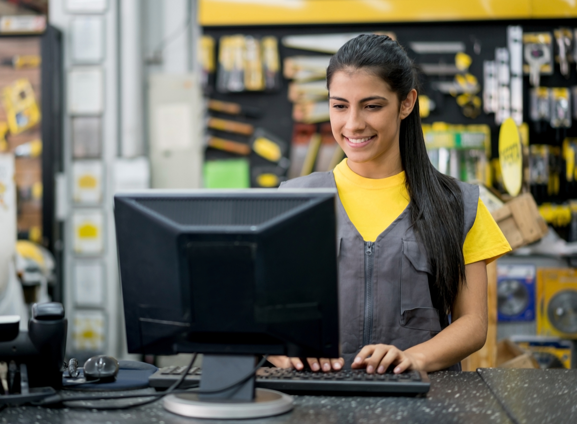 Jovem mulher que trabalha numa loja de ferramentas faz um treinamento para funcionários de forma online